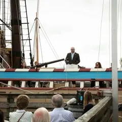 Dr. Peter Abbott OBE, British Consul-General in New England, delivers remarks from aboard Mayflower II.