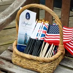 Basket of Mayflower II commemoration programs with US and UK flags.
