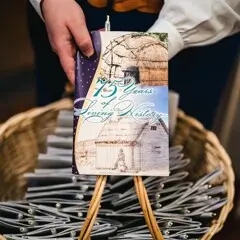Museum staff displays basket of brochures.