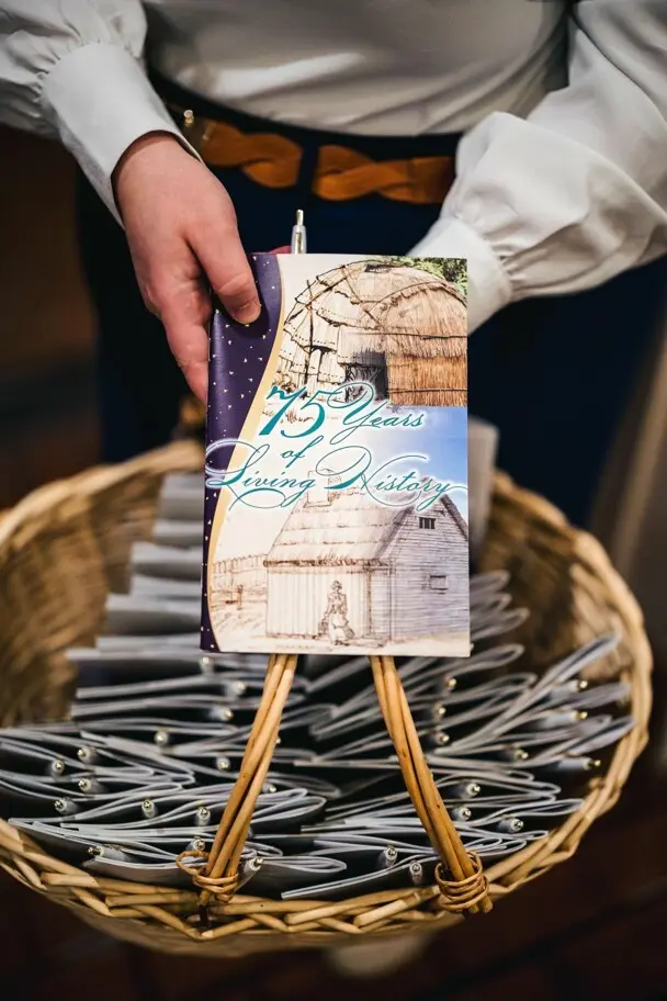 Museum staff displays basket of brochures.
