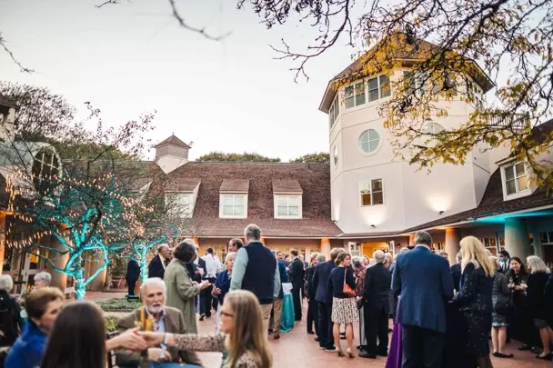 Museum guests gather for cocktail reception in courtyard.