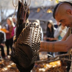 Museum educator in regalia plucks turkey on Historic Patuxet Homesite.
