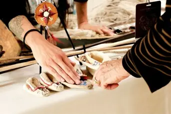 Museum educator teaches guest about regalia.