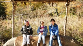 Smiling school children sit under an arbor at the Historic Patuxet Homesite.