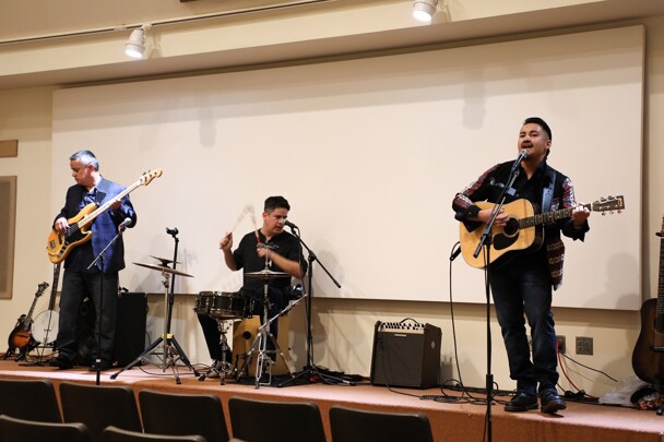 Three members of Lone Wolf and the Spaghetti Corner Band perform on stage.