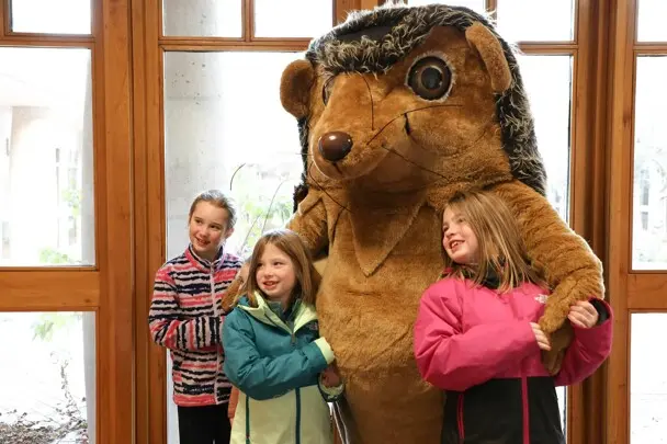 Hedgie poses for a photo with three young fans.