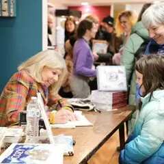 Jan Brett signs a young reader's book.