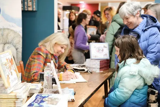Jan Brett signs a young reader's book.