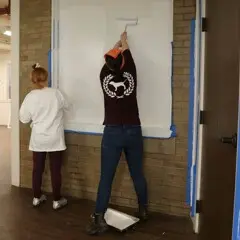 Volunteers painting craft center clean up day