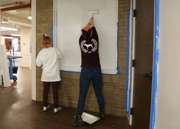 Volunteers painting craft center clean up day