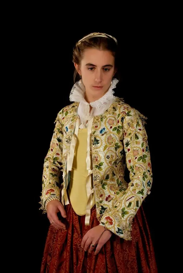 A woman models the Plimoth Jacket and 17th century clothing.