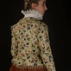 A woman models the Plimoth Jacket and 17th century clothing.