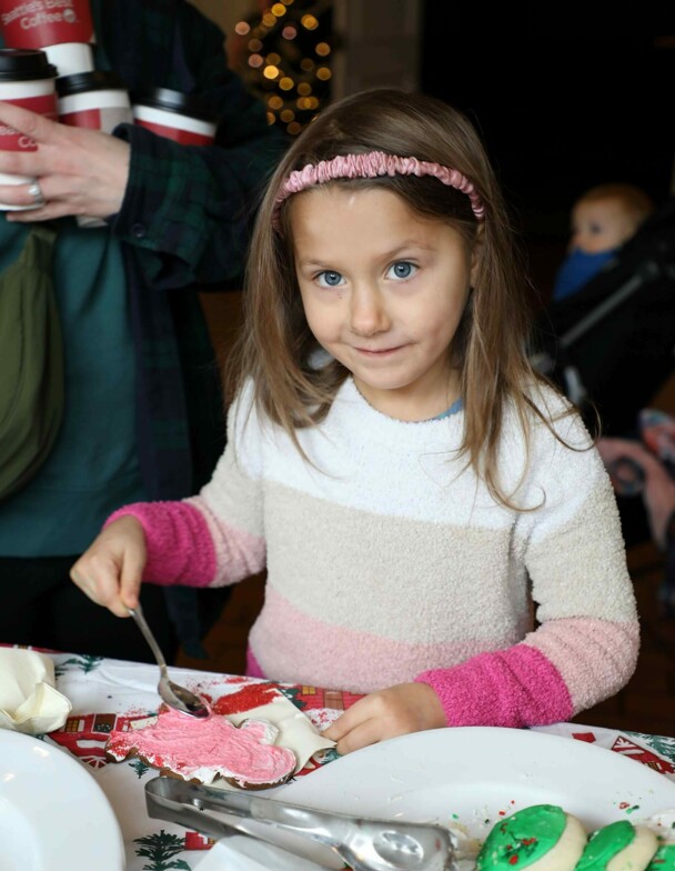 Girl decorates a holiday cookie.