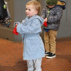 Young boy in pajamas holds a velvet bag containing a magical bell..