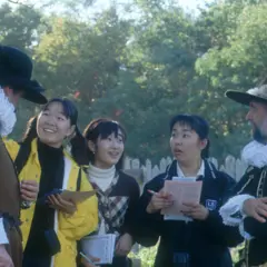 Two pilgrims with group of guests chatting