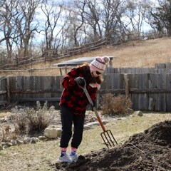 A woman works in the kitchen garden of a Pilgrim house.
