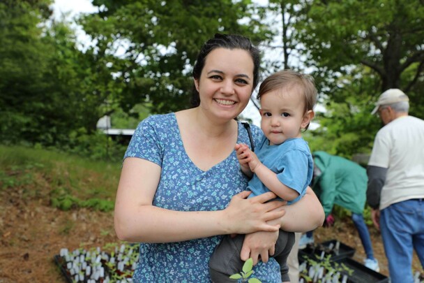 Mother poses with toddler son at plant sale