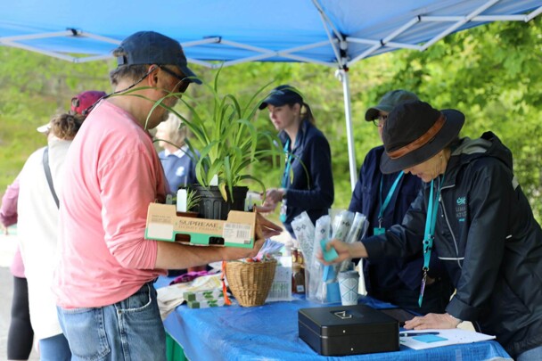 Visitor purchasing plants from Plimoth Patuxet employees at the Plant Sale