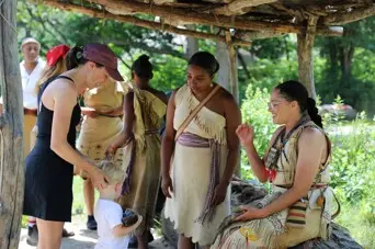 Mother and child guest engage with Educators at the Shade Arbor on the Historic Patuxet Homesite