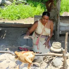 Museum Educator tends to roasting turkey at the Cooking Arbor