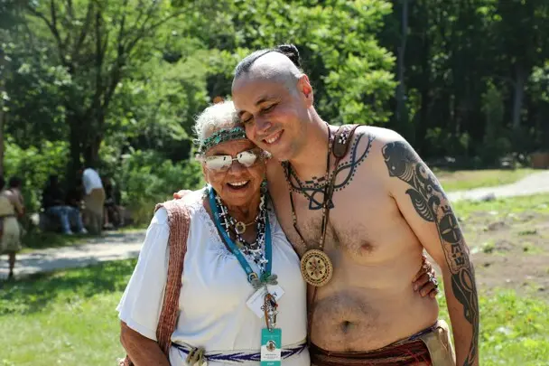 Two educators greet and hug each other on the Historic Patuxet Homesite