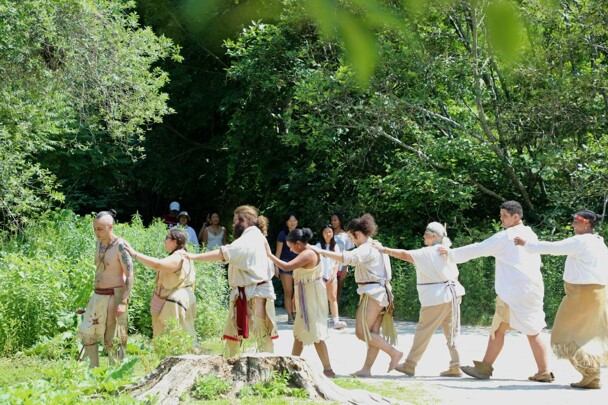 Educators demonstrate a Wampanoag dance on the Historic Patuxet Homesite in front of guests