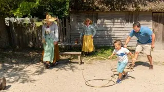 Father and son spin hoops with Pilgrims in English Village