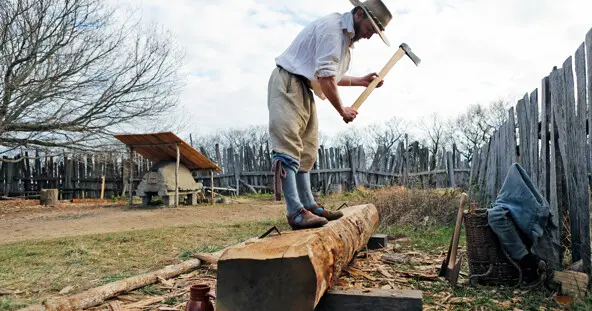 English village pilgrim working log axe chopping wood