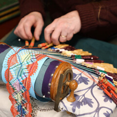 An artisan at the Winter Fine Arts & Craft Fair demonstrates how to make intricate lace patterns using bobbins.