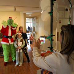 A mother snaps a photo of her daughters posed with the Grinch before the Moo-flower.