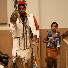 An adult and child member of Wetu Ways demonstrate a traditional dance in Plimoth Cinema.