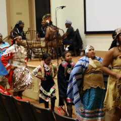 Members of Wetu Ways demonstrate a dance in front of the stage in Plimoth Cinema