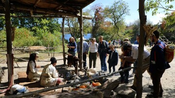 Guests gathering around cooking arbor on Historic Patuxet Homesite to engage with Educators.