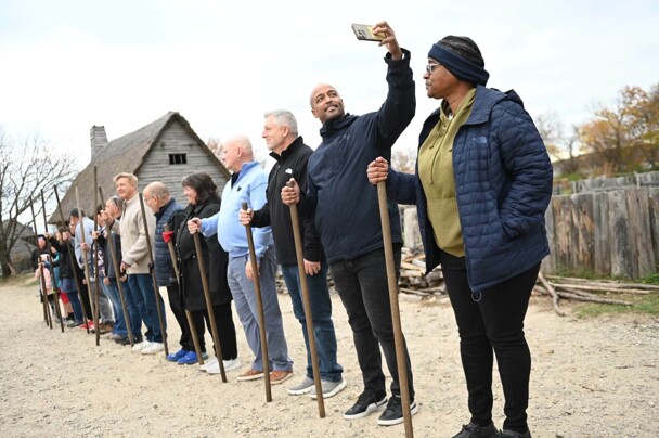 Group of adults in Muster drill. One man has a raised arm to take a selfie.