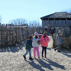 Late elementary aged students stream into the 17th-Century English Village in the late fall.