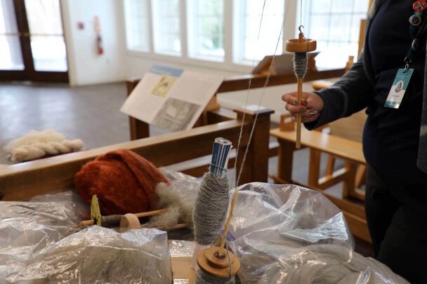 Educator spins wool in Craft Center.