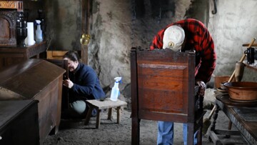 Volunteers polish pilgrim furniture