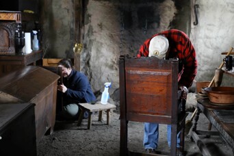 Volunteers polish pilgrim furniture