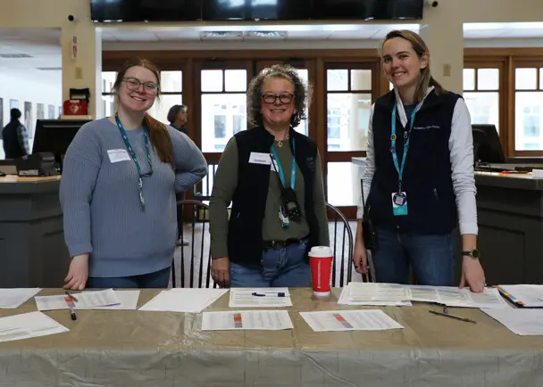 Three staffers stand ready to check-in Museum Clean Up Day Volunteers