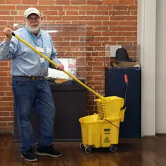 A volunteer mops the wooden floor at the Craft Center.