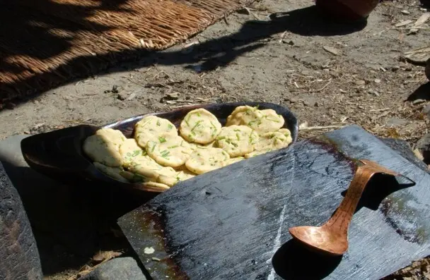 Wampanoag corn cakes placed in a wooden bowl, waiting to be cooked
