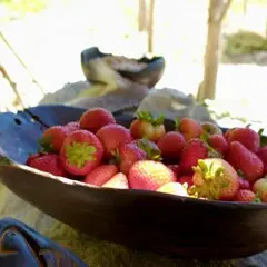 Red strawberries in a wood bowl.