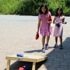 Two young girls play corn hole at the Museum.