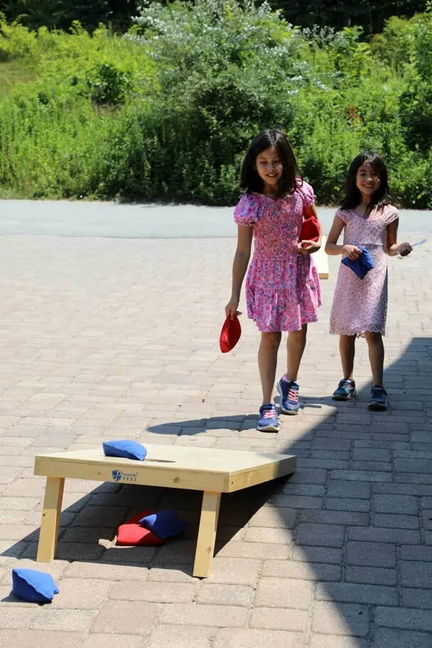 Two young girls play corn hole at the Museum.