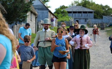 Young guests lead Pilgrim bride and her parents down the main street of the 17th-Century English Village.
