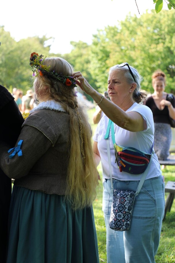 A Museum guest adjusts the Pilgrim Bride's flower crown.