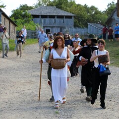 Guests lead the Pilgrim groom down the main street of the 17th-Century English Village.