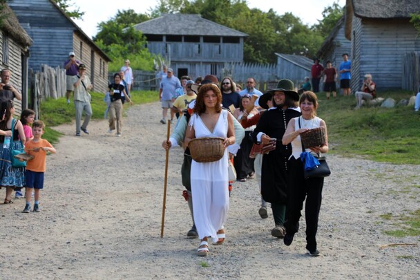 Guests lead the Pilgrim groom down the main street of the 17th-Century English Village.