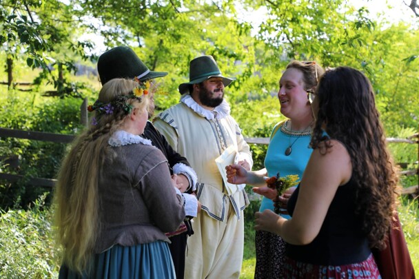 Museum guests gather to speak with Pilgrim Bride and Groom.
