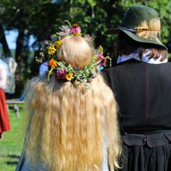Pilgrim bride and groom watch wedding guests celebrate.